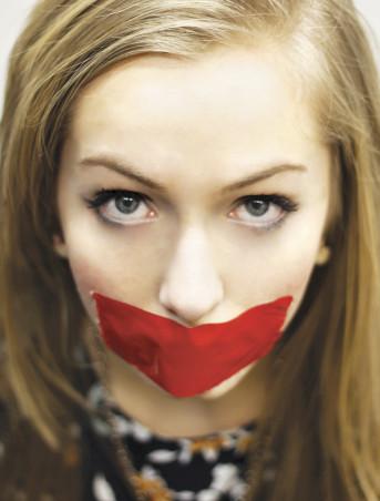 Photo of a woman with red tape over her mouth.