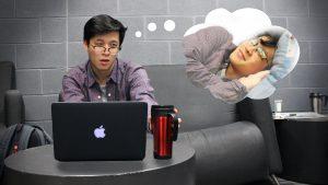 A guy at a work desk dreams about sleeping