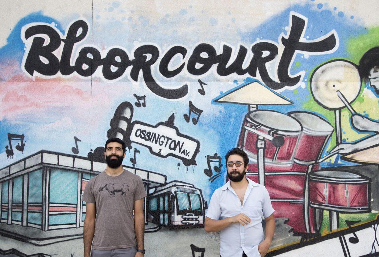 Uppal and Francouer stand in front of a Bloorcourt Mural