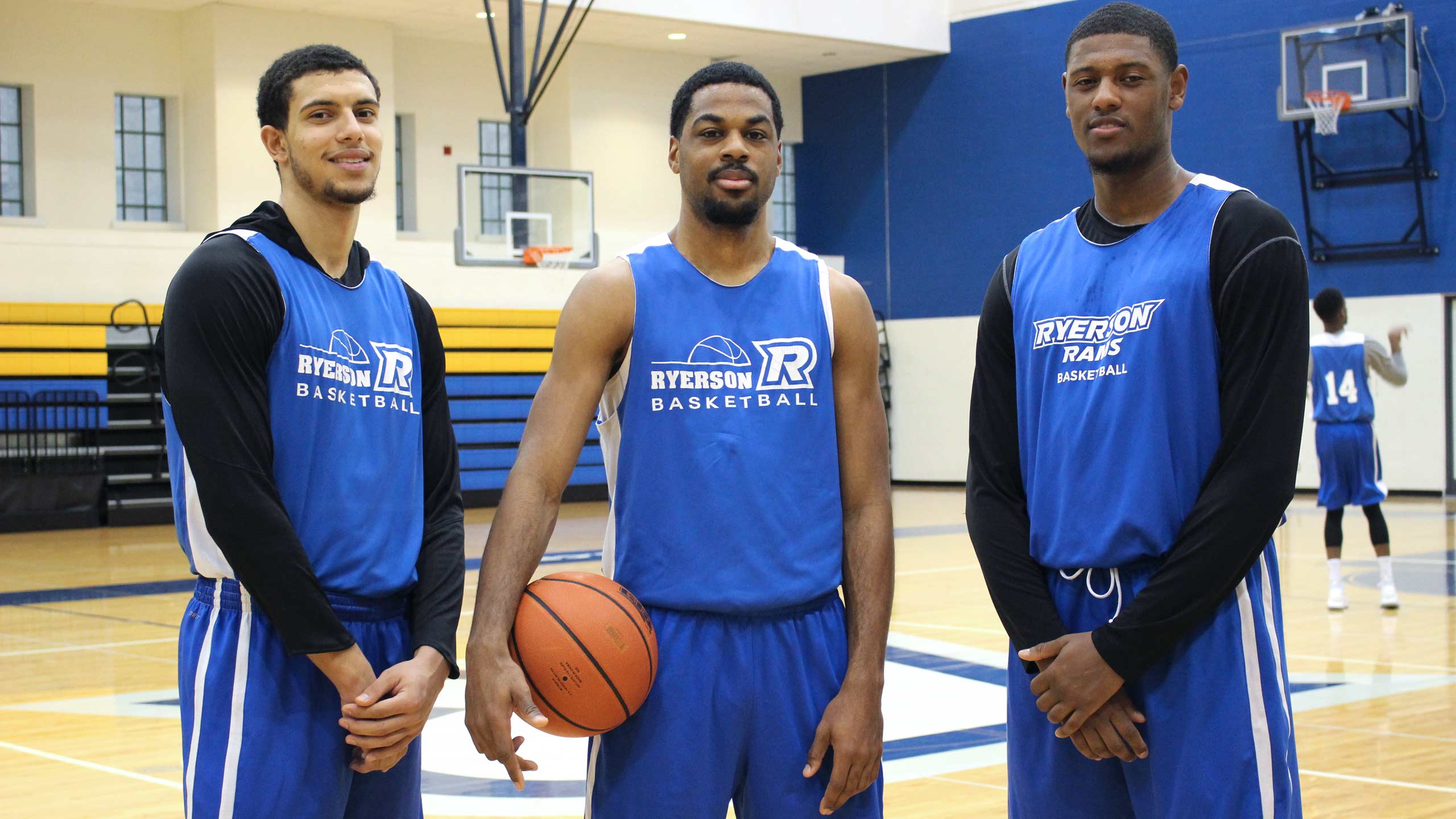 Three Ryerson Basketball team captains stand on the court
