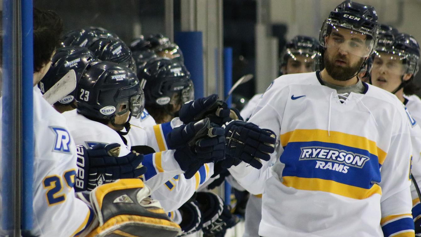 The Ryerson men's hockey players high five at the bench.
