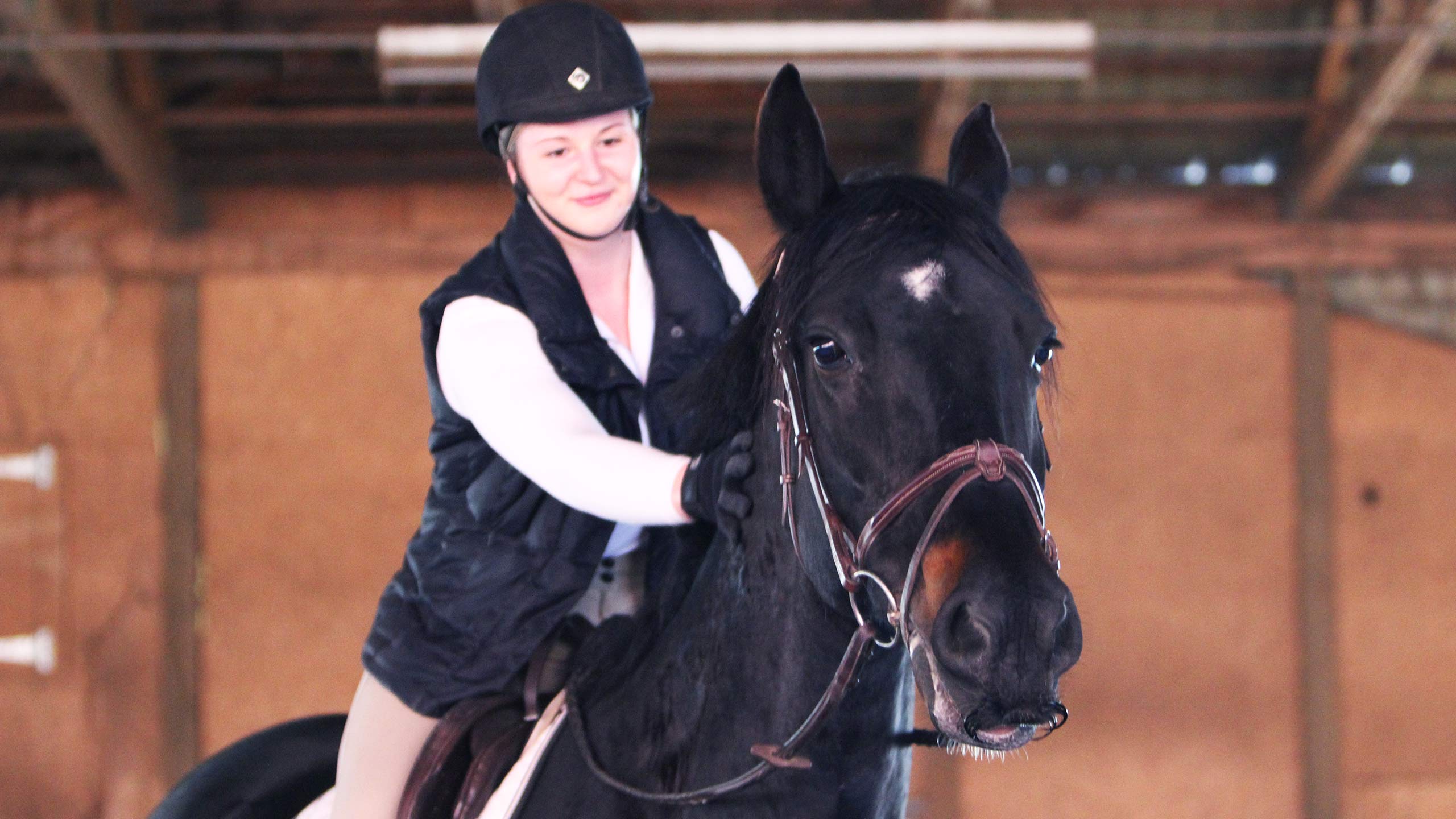 Katie stroking her horse, Onyx