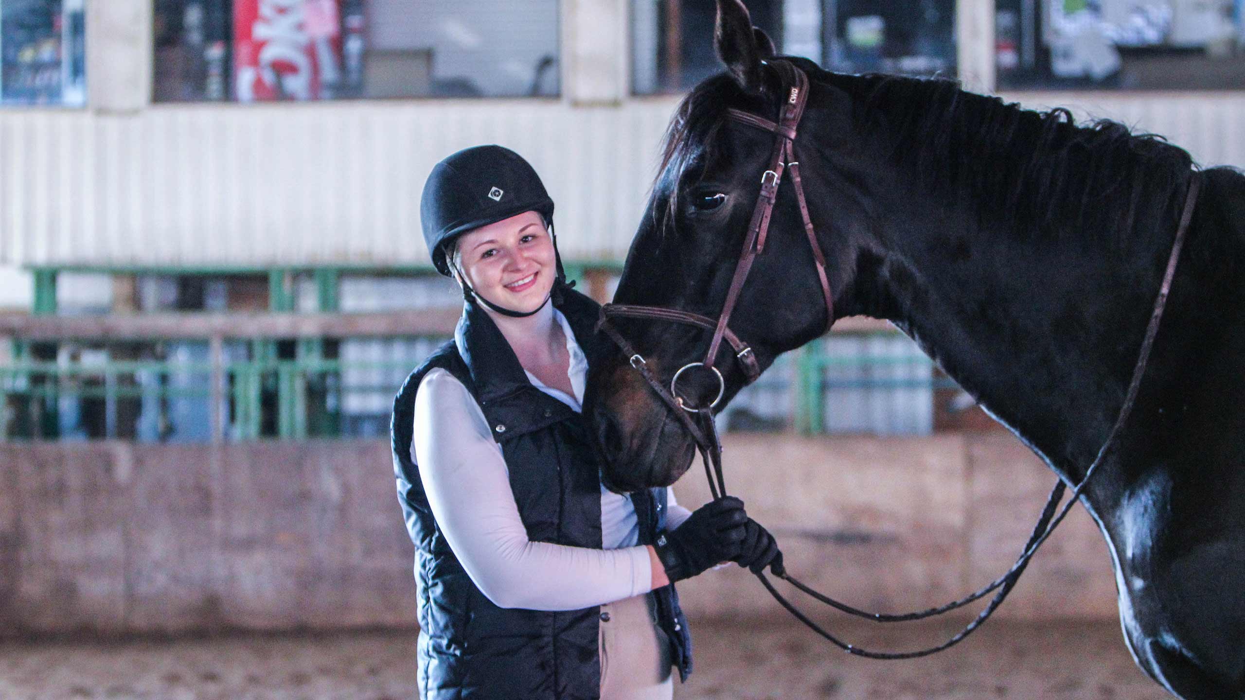Katie stands next to her horse, Onyx