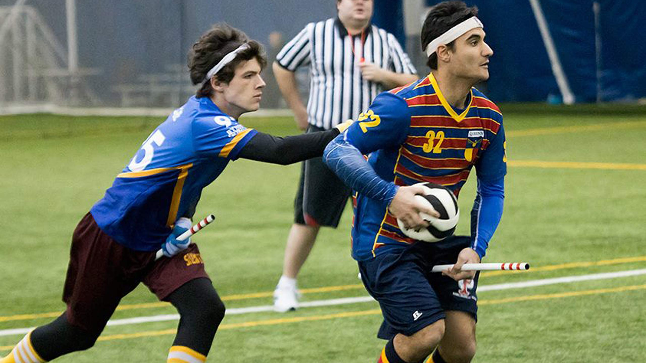 Ben Legere playing Quidditch on an indoor field.