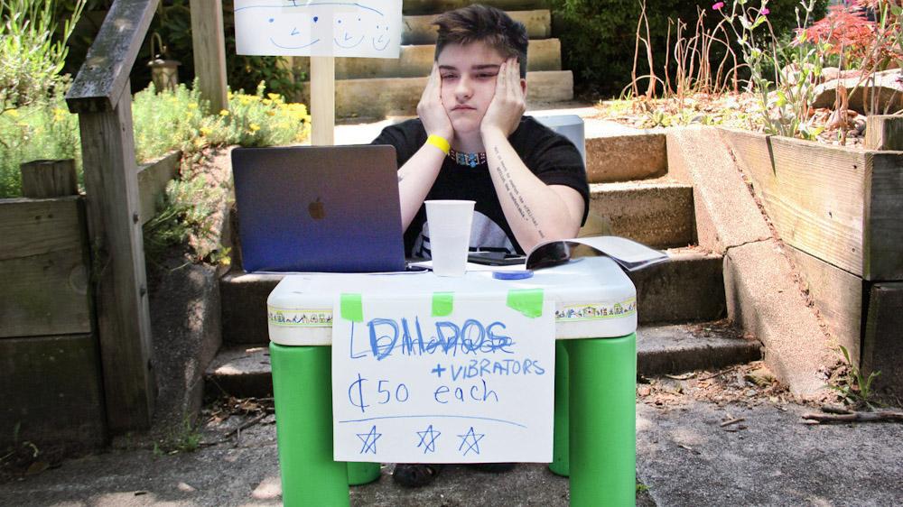 Ryerson student union member selling dildos at a plastic table lemonade stand