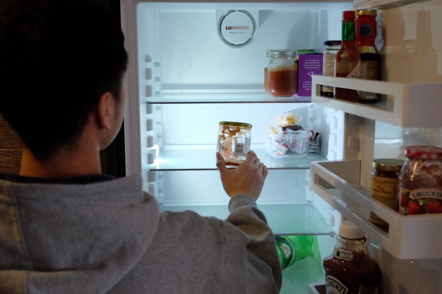 A student looks into an empty fridge
