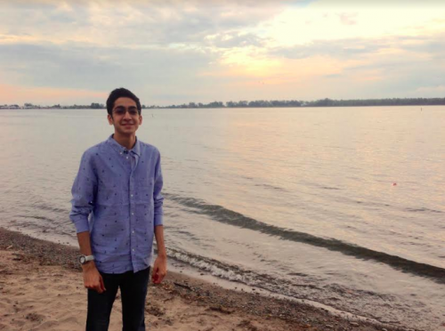 Young man standing in front of sunset