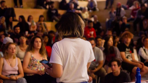 An individual stands in front of a crowd of listeners in the SLC, speaking to the strike