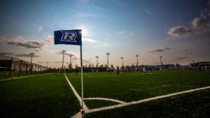 A photo of the Ryerson soccer field at sunset with a Ryerson flag in the middle