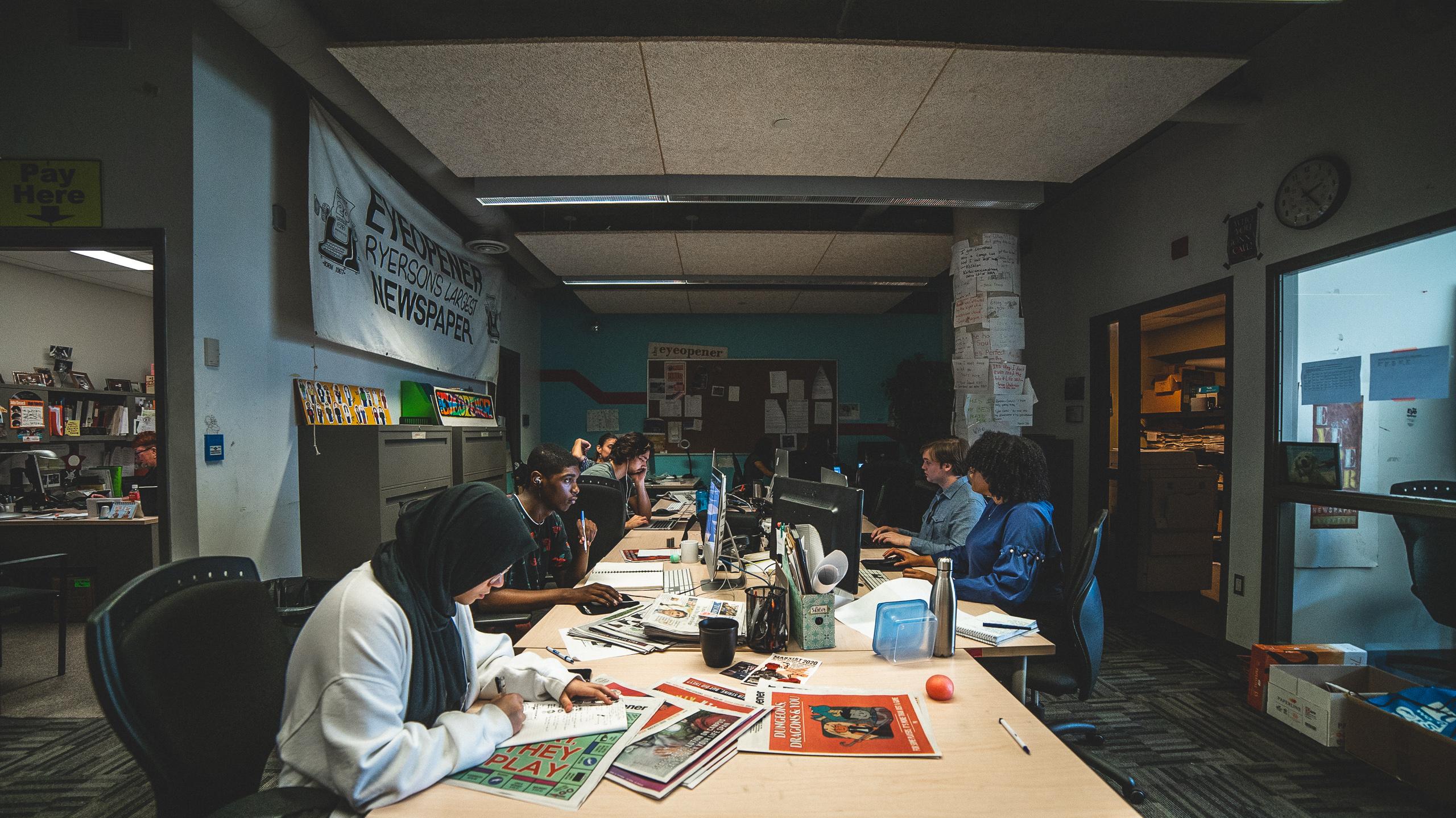 A photo of the Eyeopener Fall 2019 Masthead working in their office