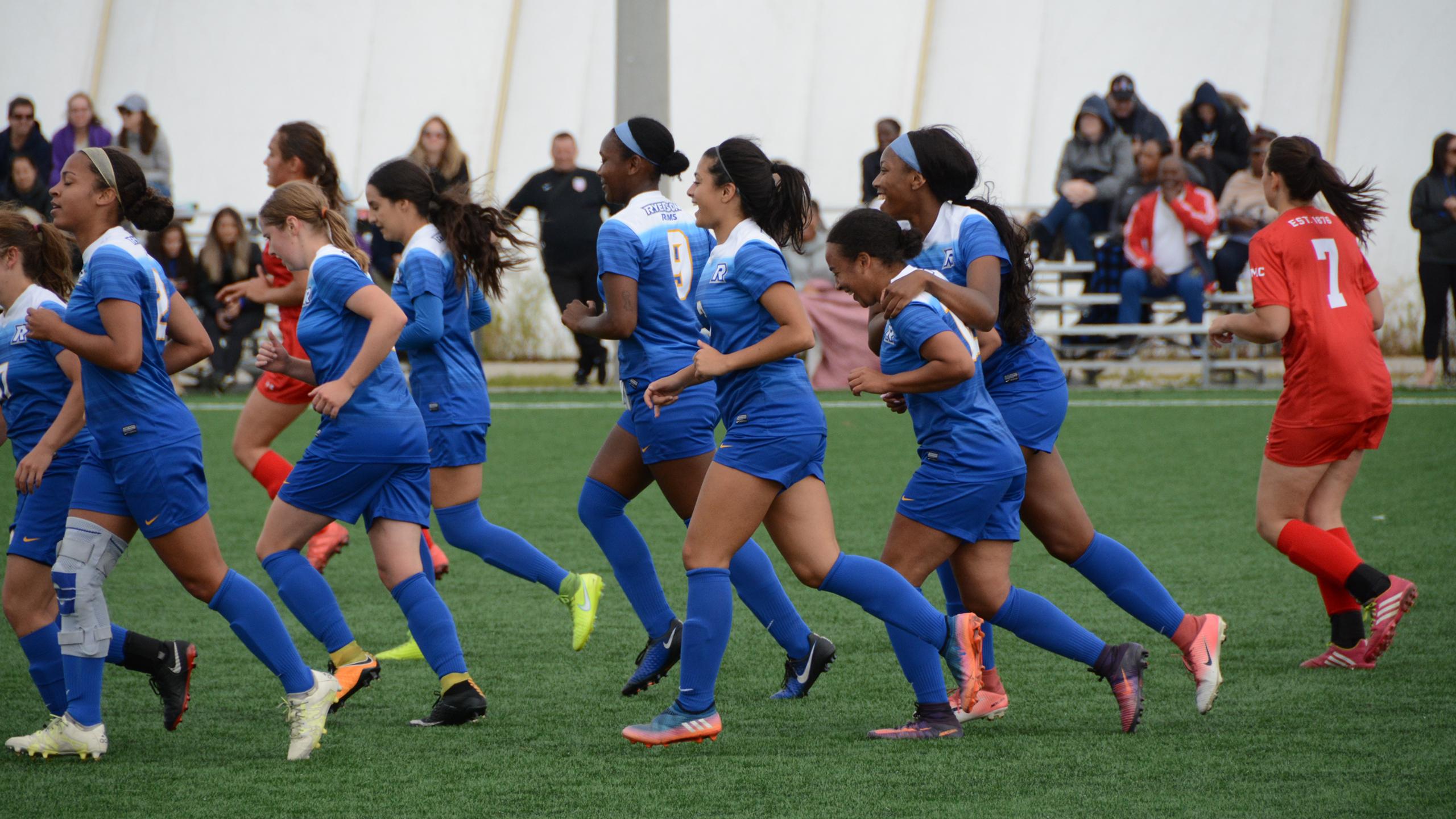 A photo of female Ryerson students running across a soccer field