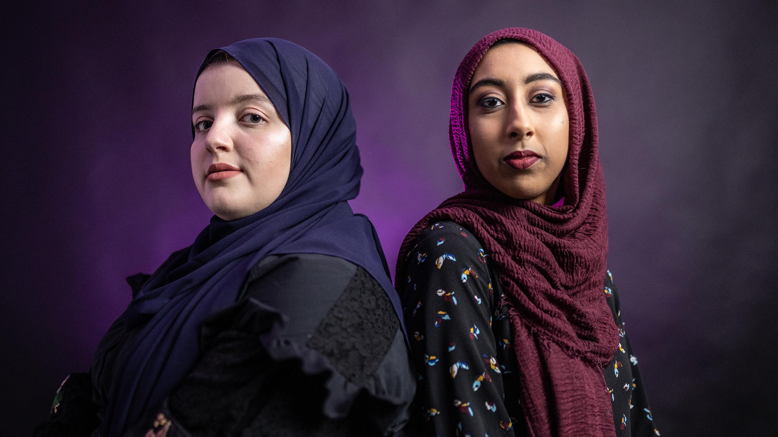 Two hijabi women, one of lighter and one darker complexion, stand side by side