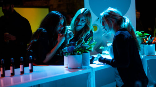 Two women stand against a counter smelling a room mist product from Sundial