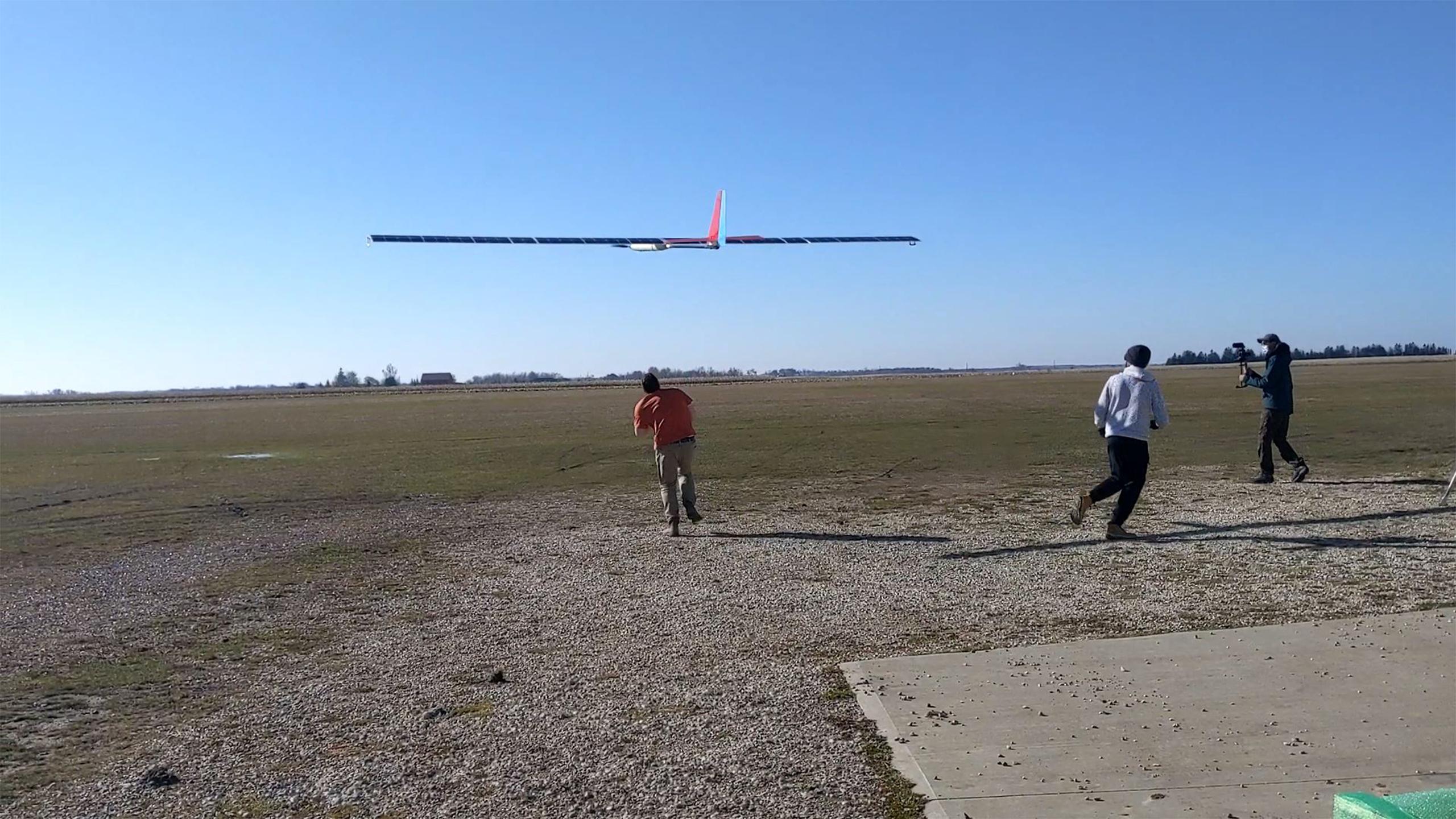 Glider flying above a field.
