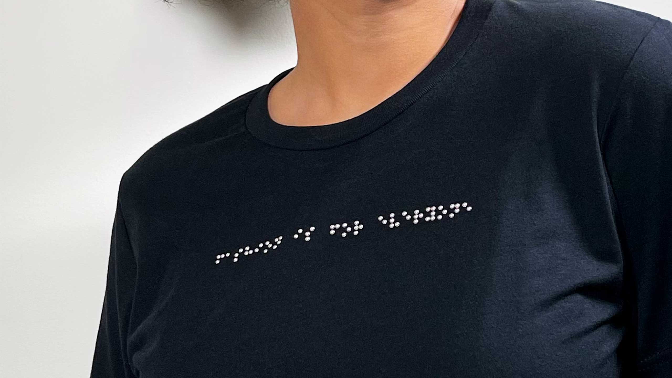 A dark shirt with braille writing on it.