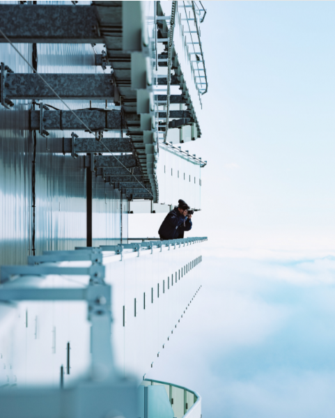 Someone taking a picture over a high balcony in the clouds