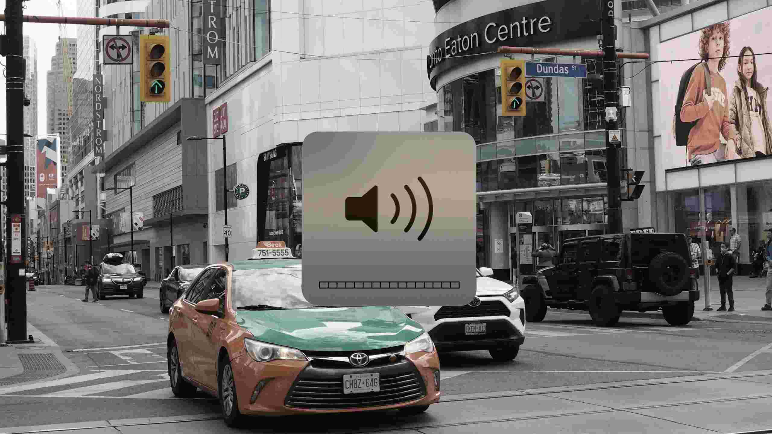 A taxi driving through Yonge-Dundas intersection covered by a volume slider at max volume