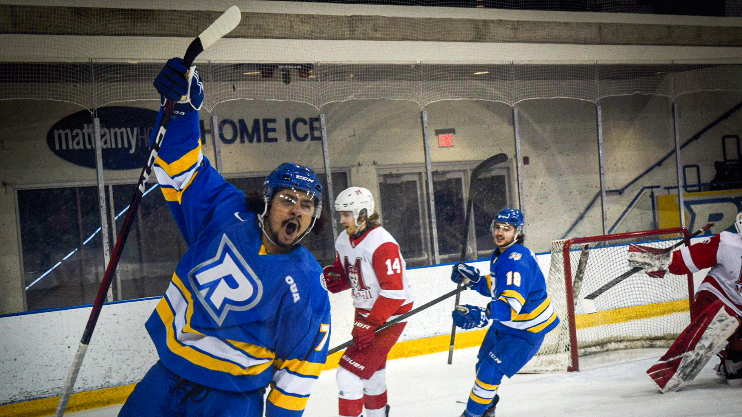 A Rams men's hockey player in a blue jersey celebrates a goal