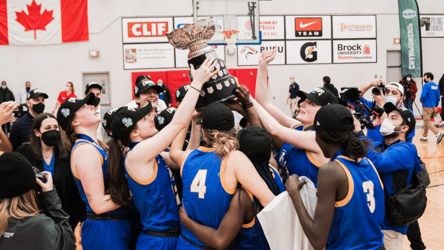 The Rams women's basketball team in blue jerseys celebrate a championship victory