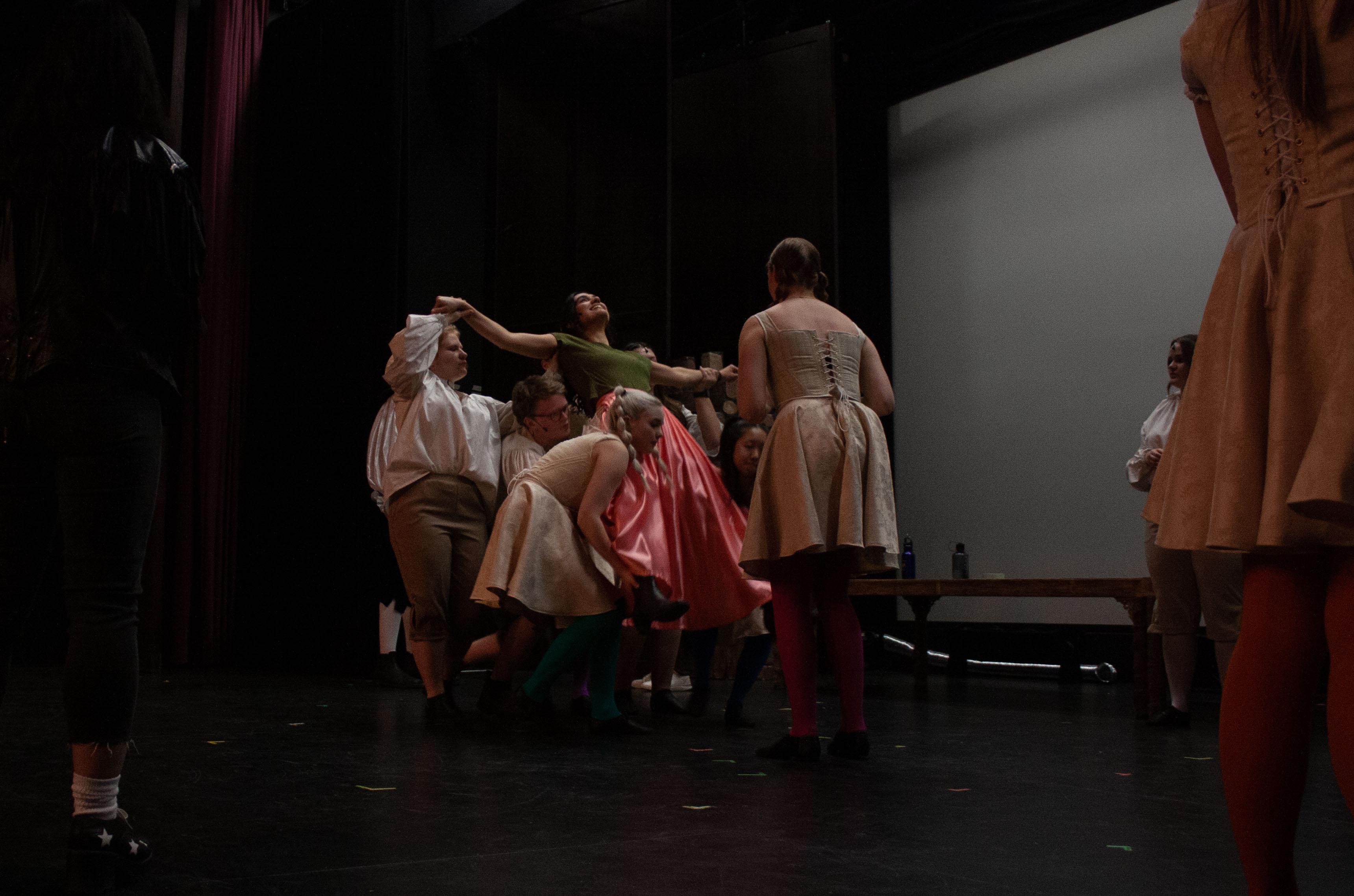 Actors practicing a lift on stage.