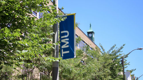 A TMU sign on a lamp post on Gould Street