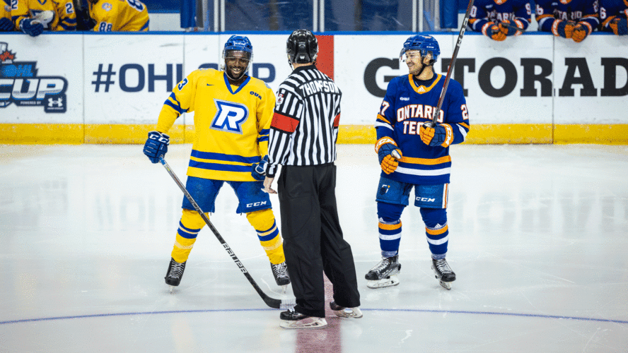 A hockey player in a yellow jersey lines up for a face-off