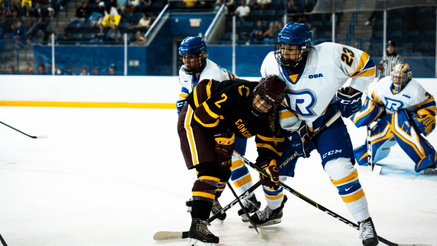 A TMU Bold women's hockey player battles with an opponent in front of the net