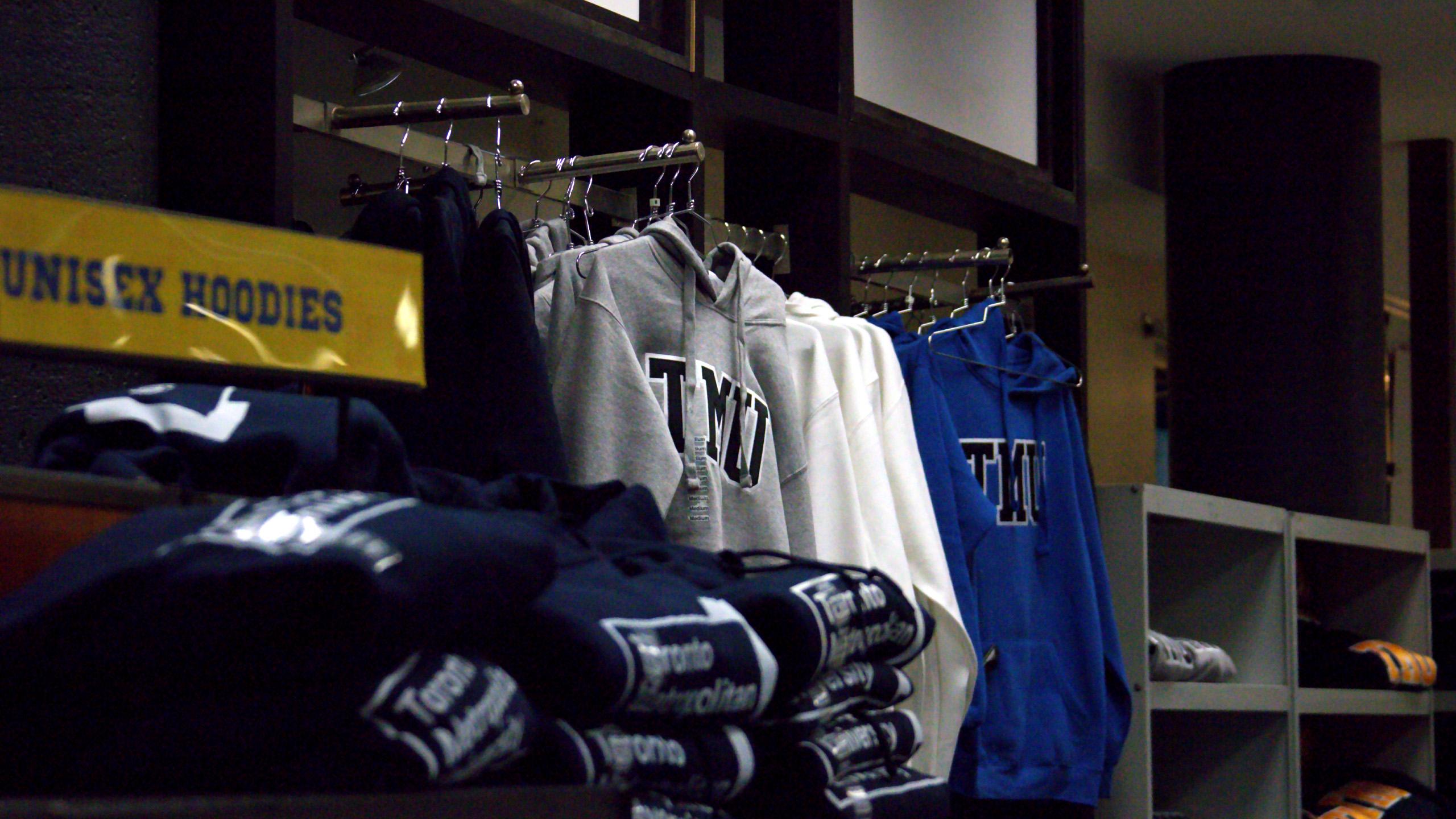 a photo in the campus store showing sweaters hanging that say TMU