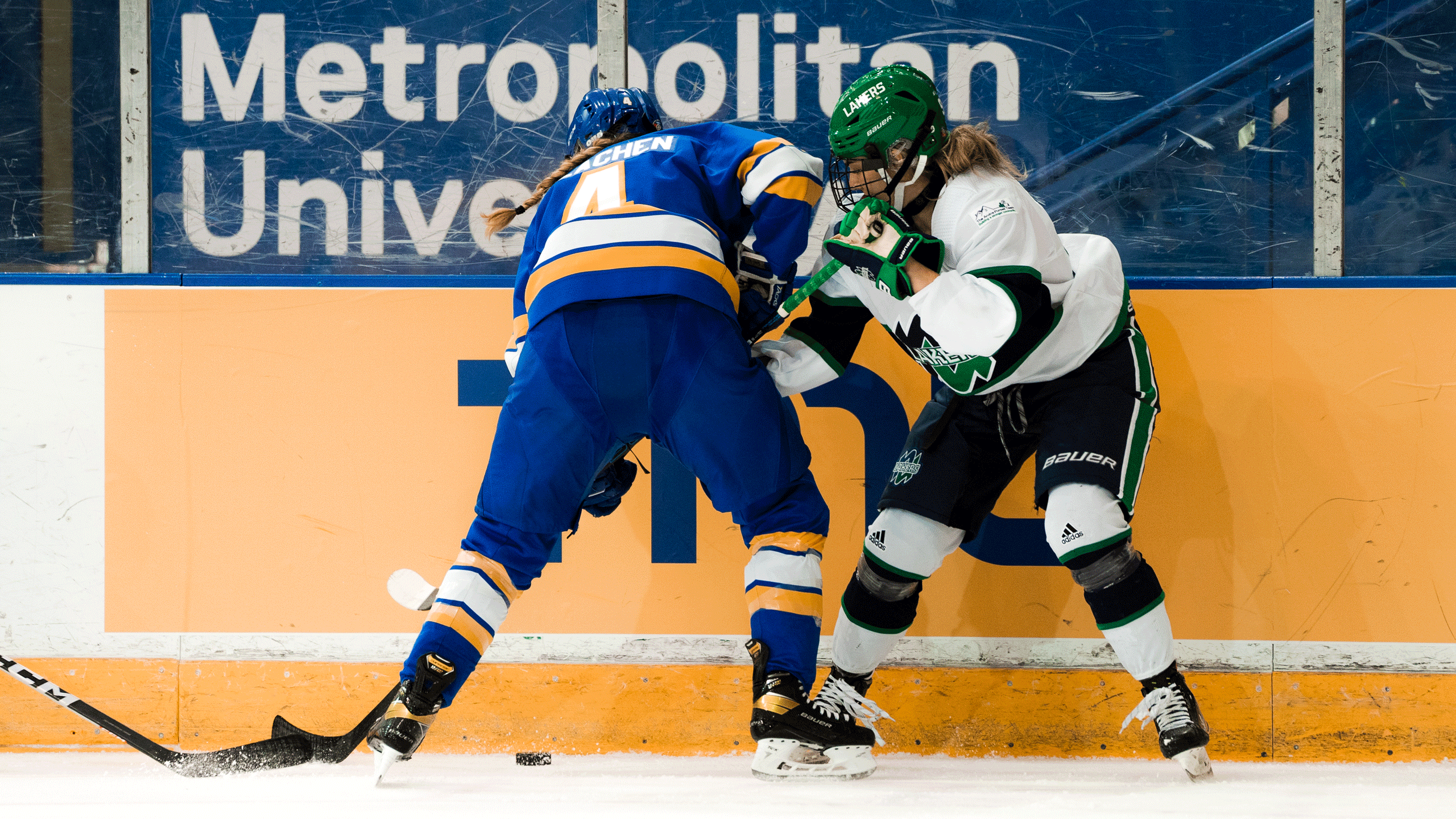 A hockey player in a blue jersey fights for the puck