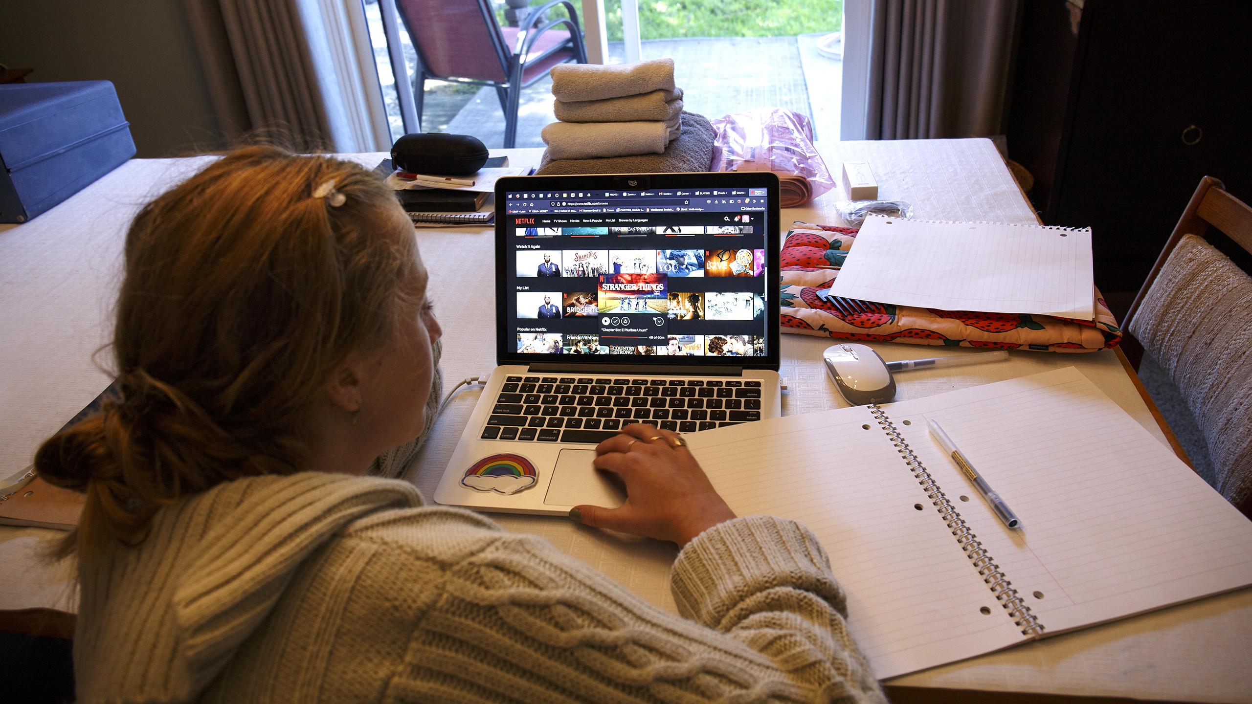 A student becomes distracted away from midterm prep and begins scrolling on Netflix