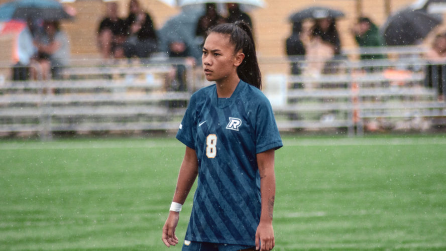 A TMU women's soccer player in a blue jersey looks at the camera