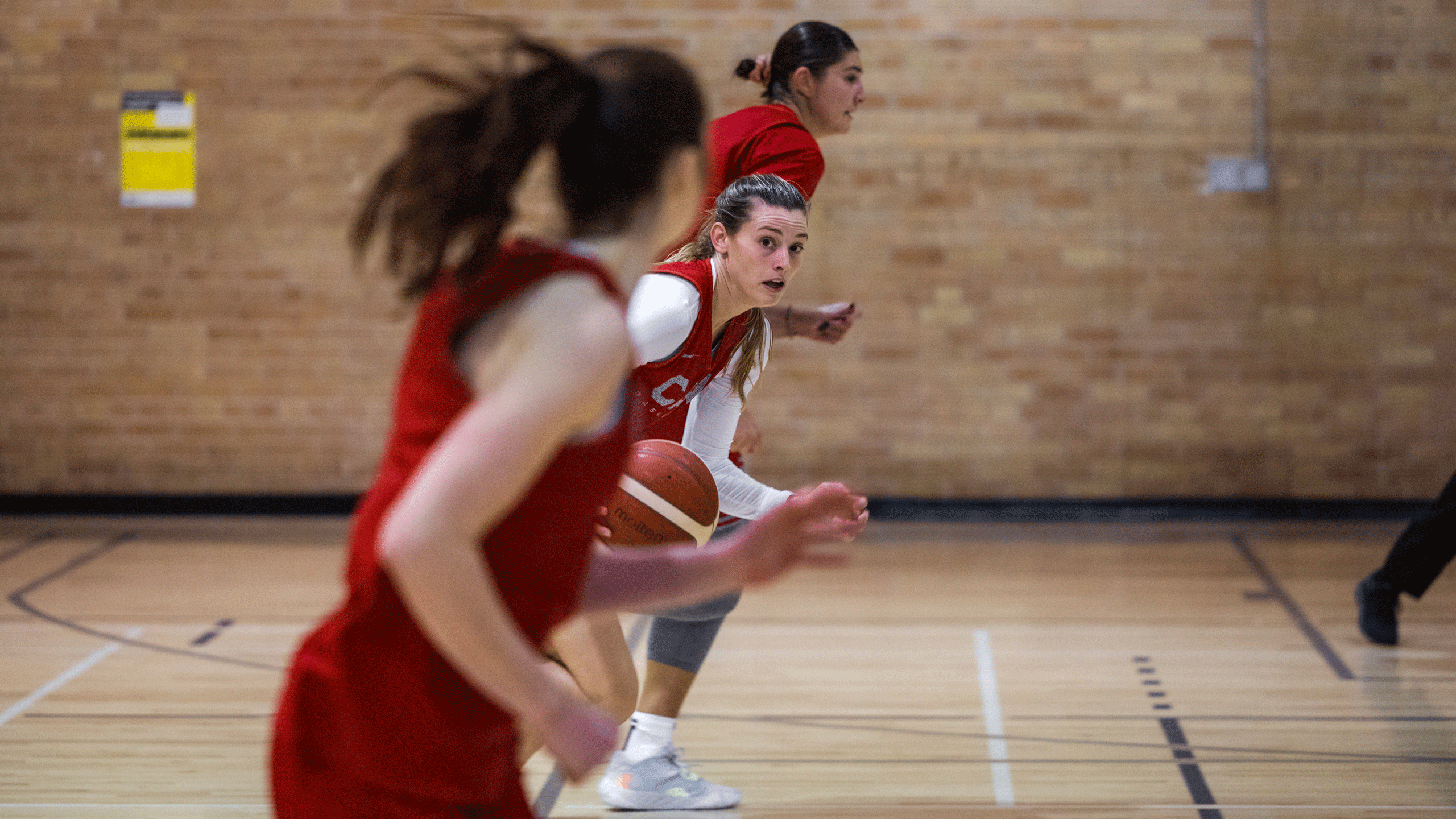 A basketball player in a red jersey runs down