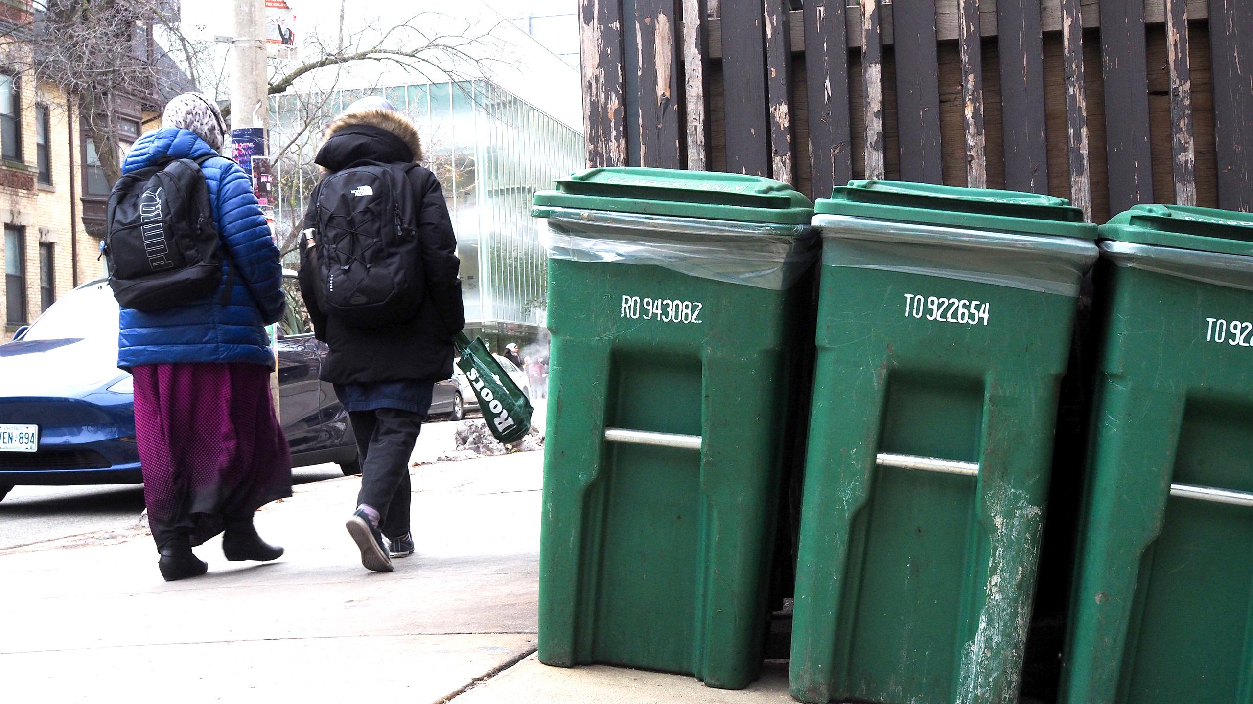 Students walking by compost bins on campus