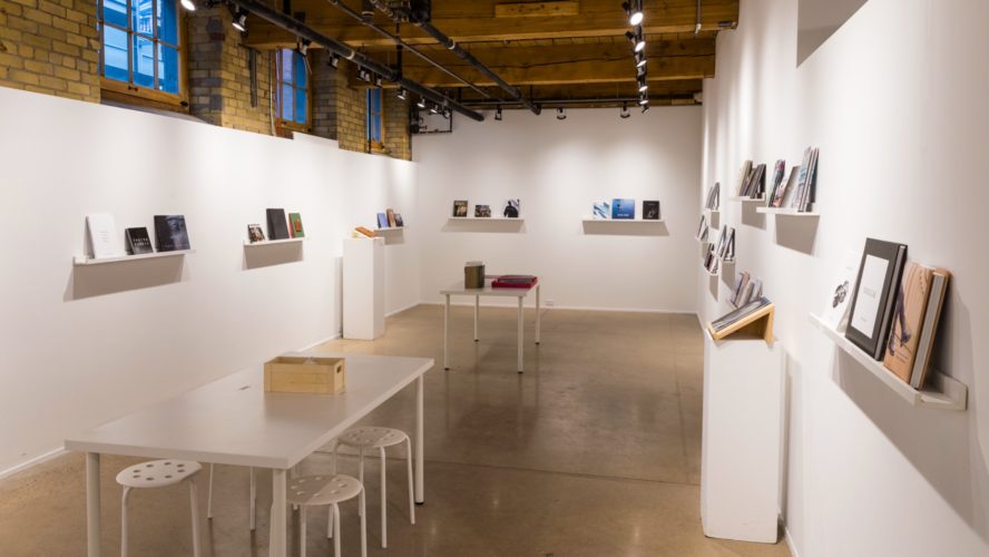image of the artspace, a white room with shelves and books on the shelves