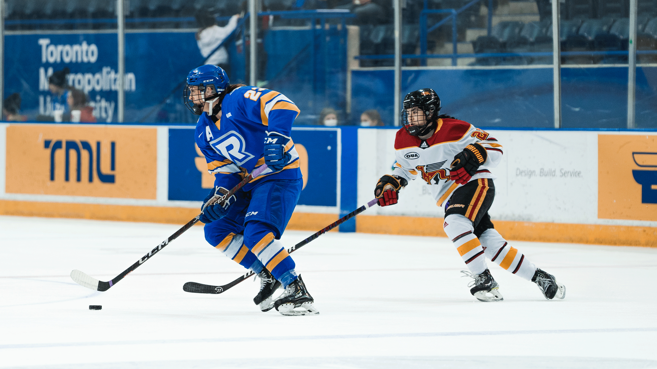 A hockey player in a blue jersey skates with the puck