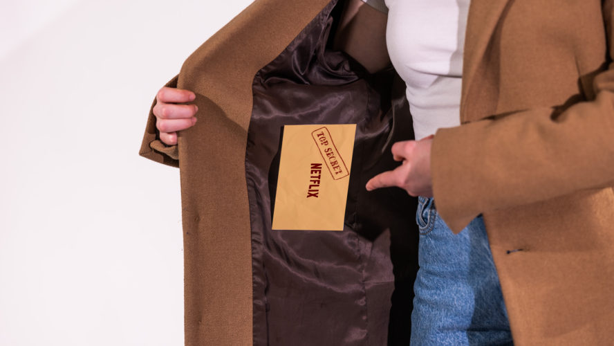 a photo of a person opening their trench coat with the netflix passwords in the coat