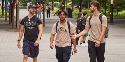 Three Students walk and talk outside Toronto Metropolitan University (TMU).