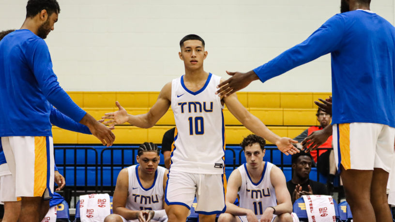 TMU Bold men's basketball players on the court at the MAC