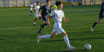 TMU Bold men's soccer player Luca Di Marco runs with the soccer ball