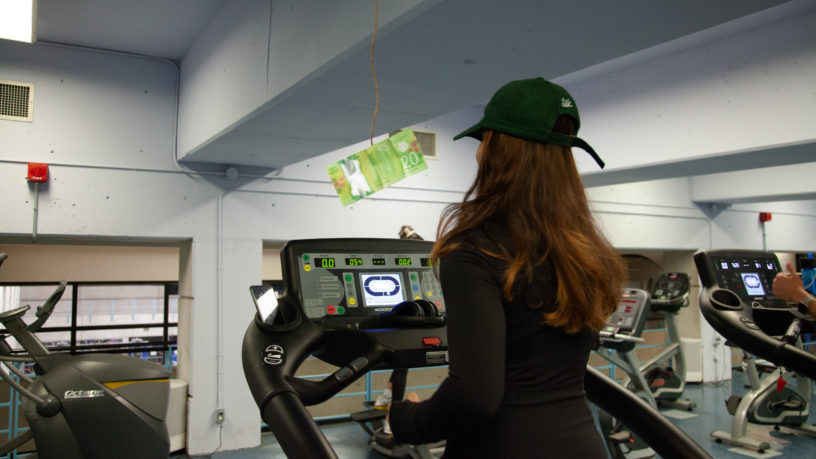 Person on a treadmill with a twenty dollar bill dangling in front of them