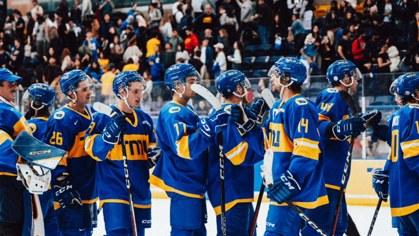 TMU Bold men's hockey team captain Chris Playfair fistbumps his teammates in celebration of a win