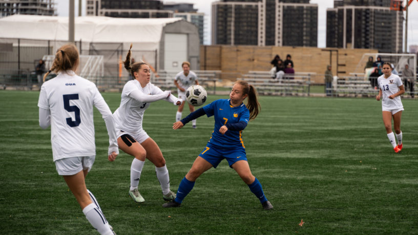 TMU Bold women's soccer player Maria Poveda heads the ball in front of a Laurentian Voyageurs player