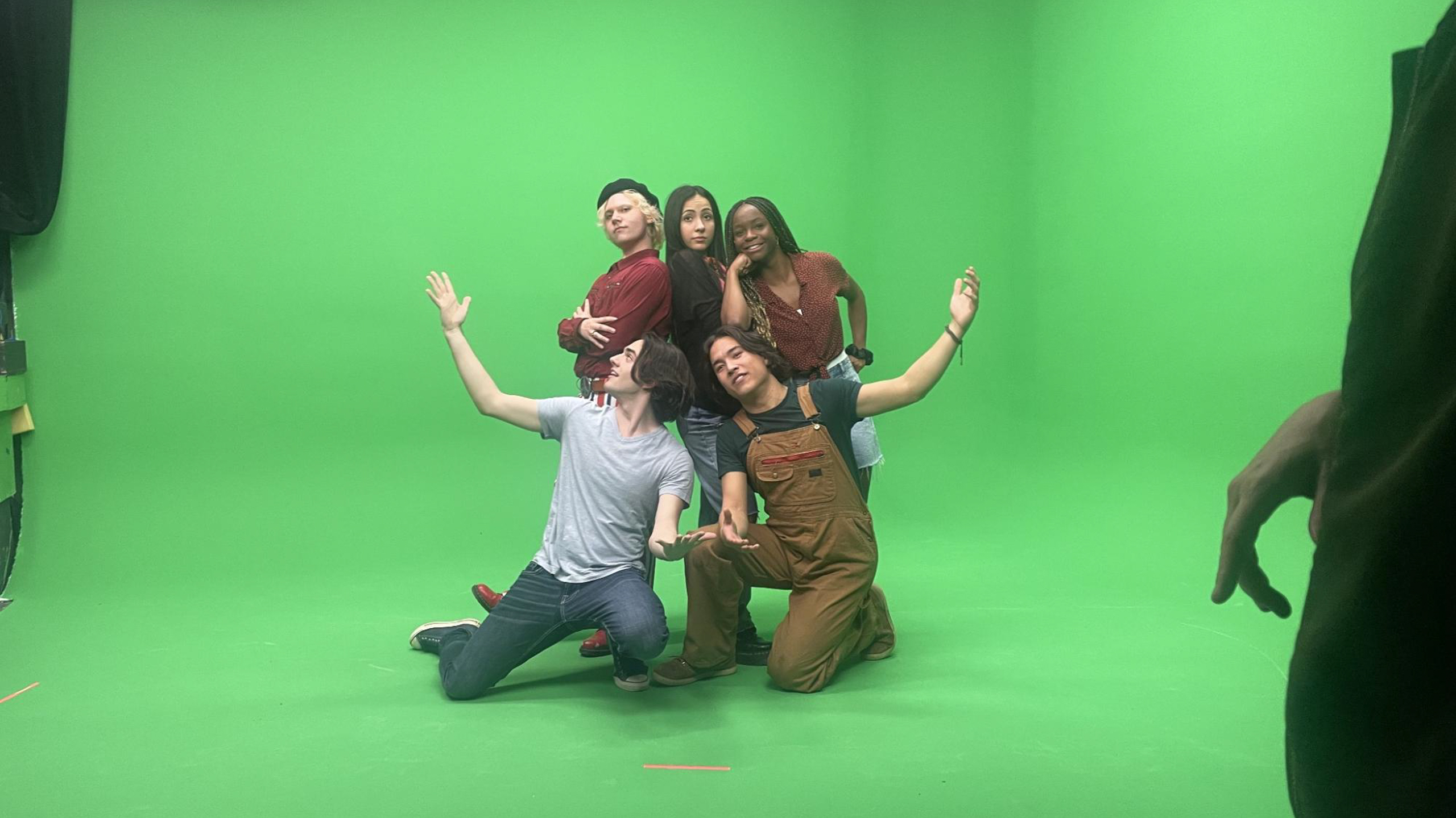 Group of people posing in front of the green screen