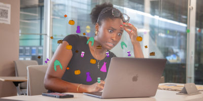 Woman surprised looking at laptop screen with illustrations