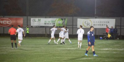Players from the TMU men's soccer team hug while celebrating a goal