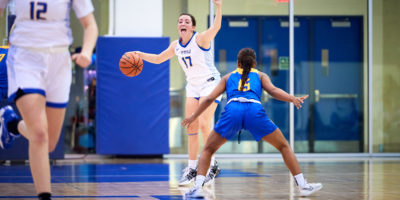 Bold women's basketball player Catrina Garvey calls for help from teammates while dribbling the basketball up the court