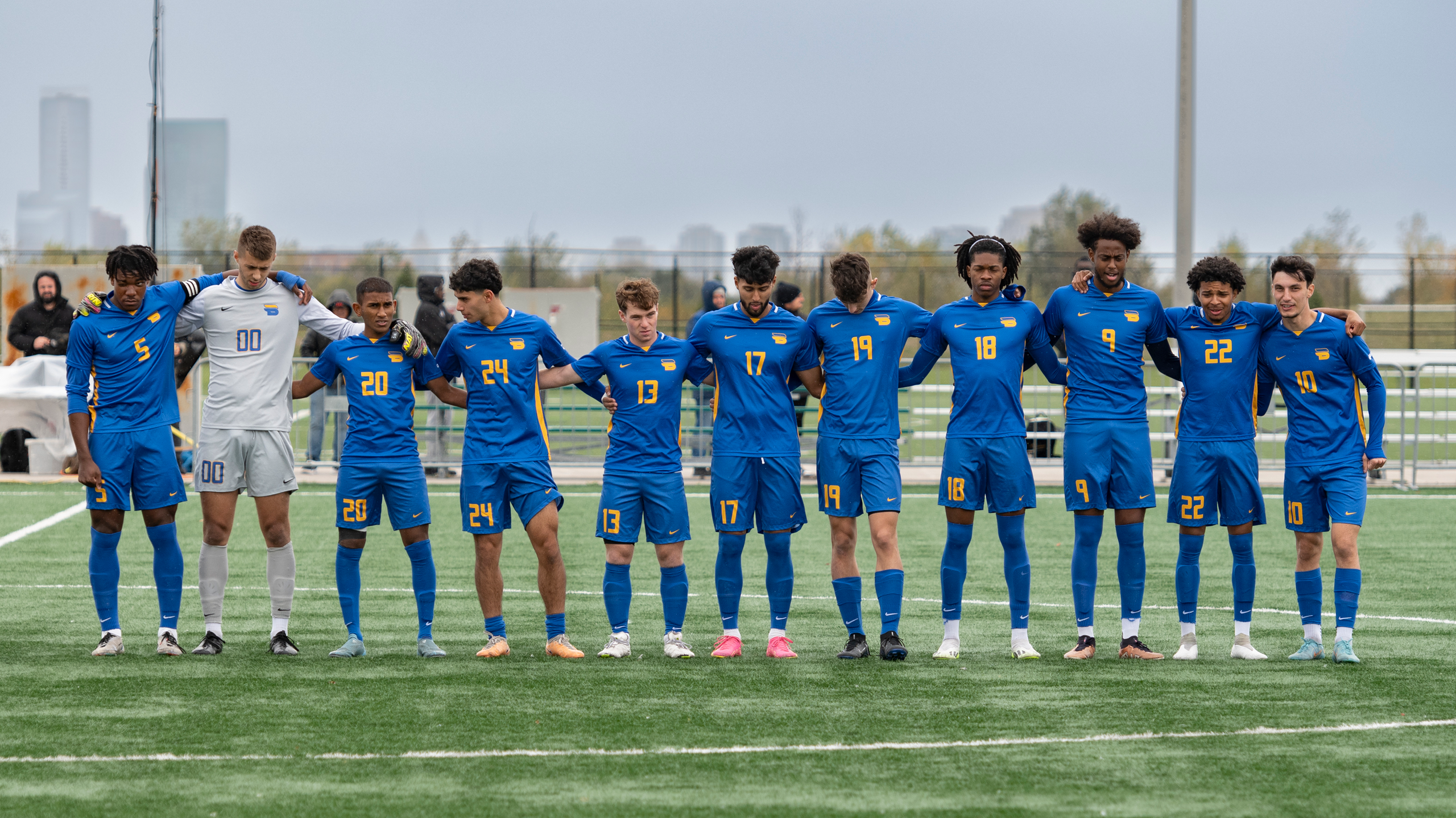 The TMU Bold men's soccer team stands together on a soccer field