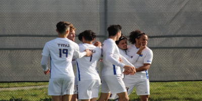 The TMU Bold men's soccer team celebrates at Downsview Park