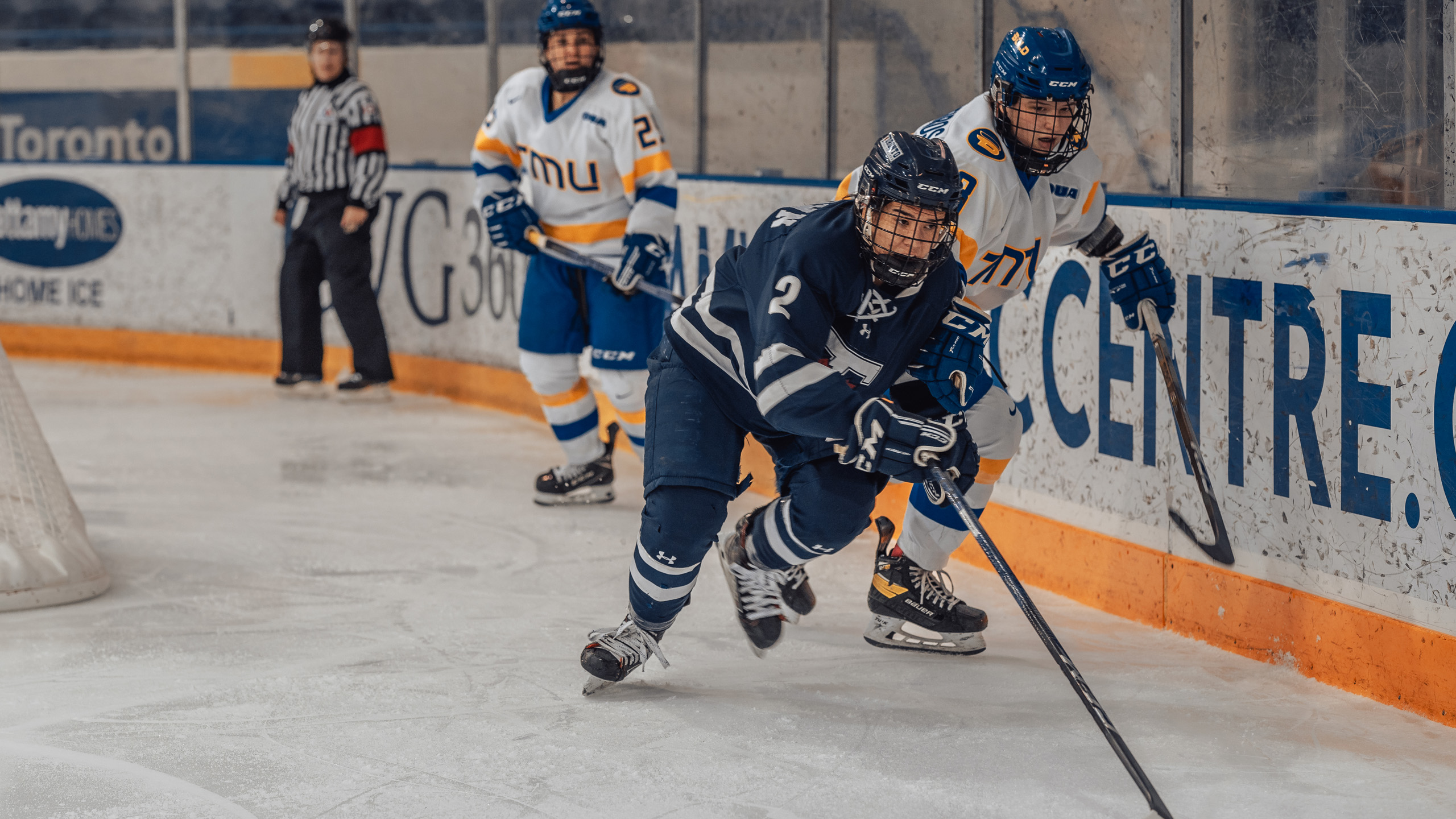 A U of T women's hockey player skates for a loose puck