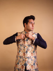 Portrait of a man looking sideways and fixing his suit button